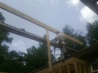 Carpenter setting a ridge beam over a new addition frame — Ice Dam Removal by Roofing Brothers in Beresford